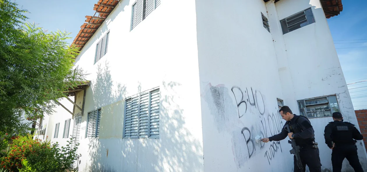 Blocos de apartamento com pichações do Bonde dos 40 sendo apagadas